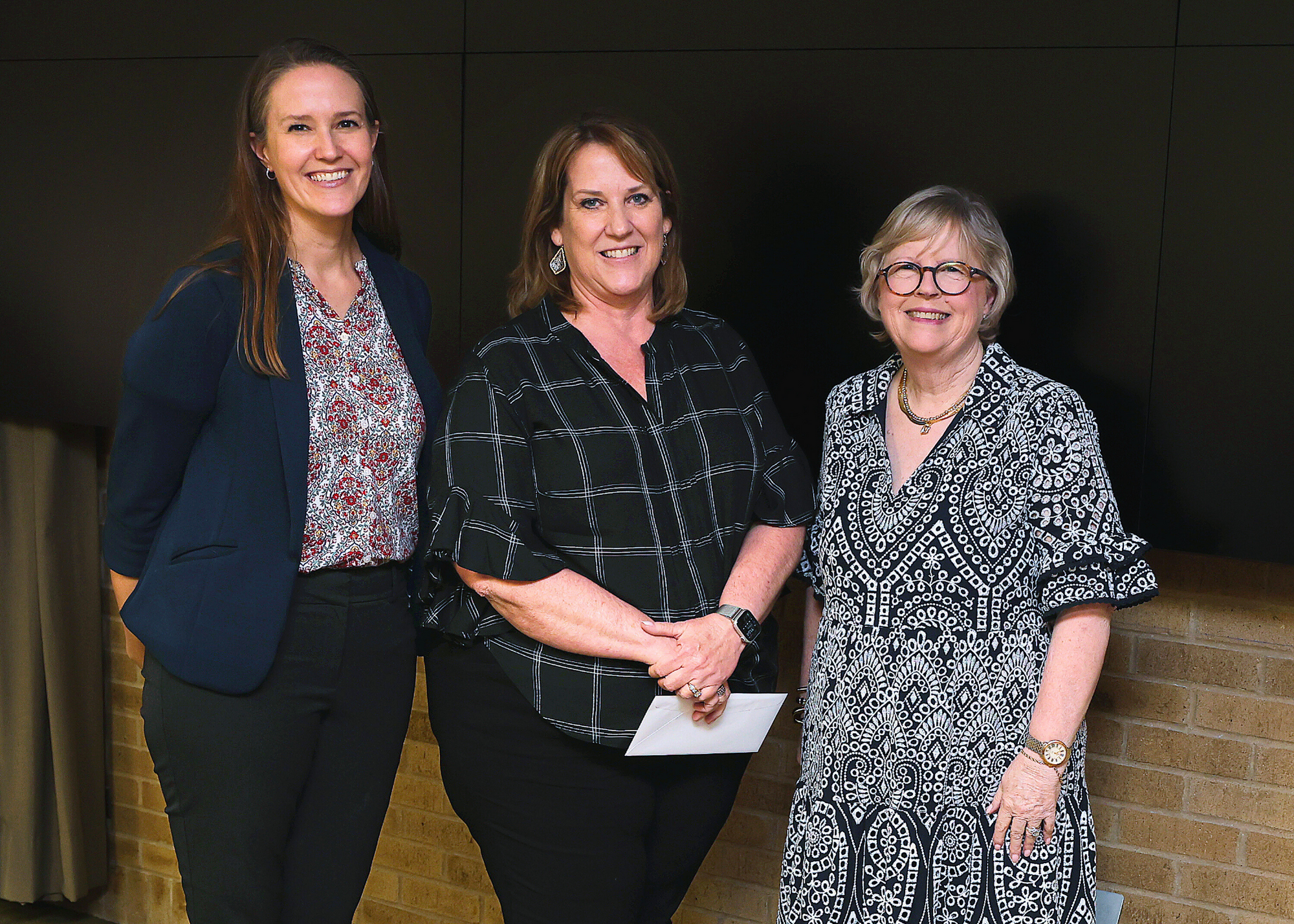 Longevity service award winner standing between the University Librarian and a representative from the Friends of the Texas A&M University Libraries